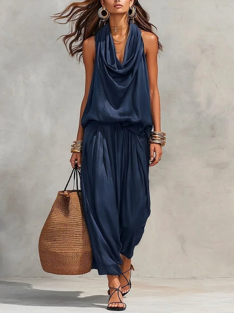 Woman wearing Simona Two-Piece Top & Pants Set in navy, carrying a straw bag, showcasing chic casual style.