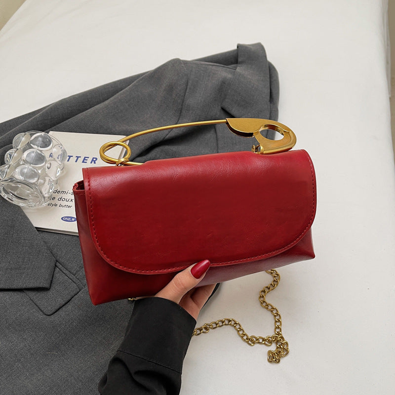 Luxury PU Leather Chain Shoulder Bag for Women in red with gold accents, styled with a gray blazer.