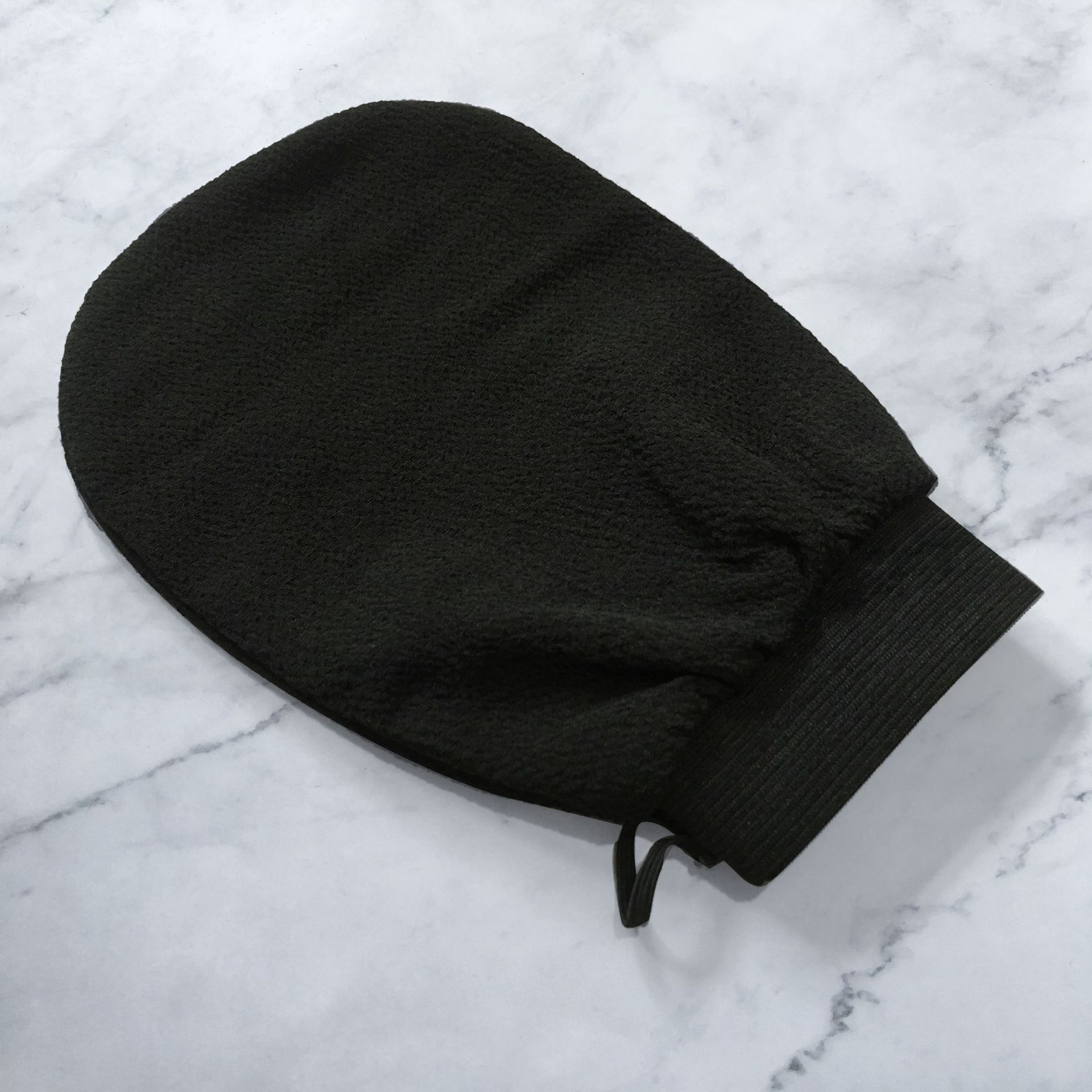 Scrub Exfoliating Gloves for Deep Cleansing & Smooth Skin on a marble surface.