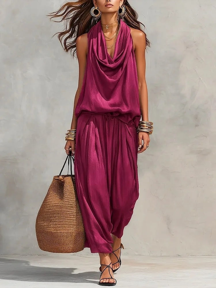 Model wearing the Simona Two-Piece Top & Pants Set in burgundy, featuring a stylish draped look and accessorized for summer outings.