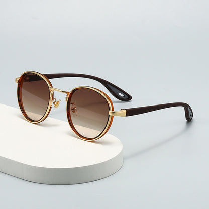 Vintage designer outdoor sunglasses with brown gradient lenses and gold accents on a light background.