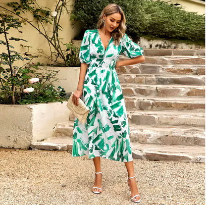 Woman wearing a Summer V-Neck Printed Maxi Dress with green leaf patterns on a sunny day.